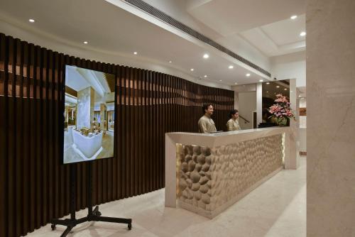 two men standing behind a counter in a lobby at Hotel Heritage formerly known as Comfort Inn Heritage in Mumbai