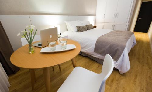 a hotel room with a bed and a table with a laptop at Gran Hotel Flores in Trinidad