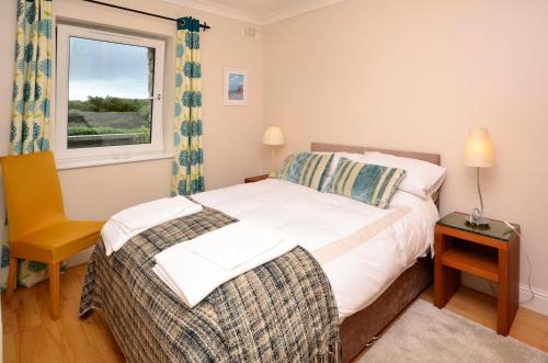 a bedroom with a bed and a window and a chair at Apartment 263 - Clifden in Clifden
