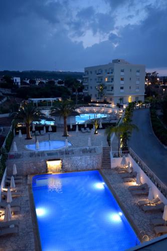 a pool at a resort at night at Sunrise Gardens Aparthotel in Protaras