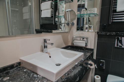 a bathroom with a white sink and a mirror at Mercure Kyiv Congress in Kyiv