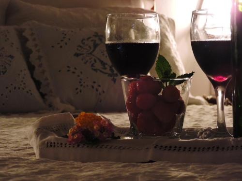 a glass of wine and a plate of fruit on a table at Pousada Araujo Bazilio in Tiradentes