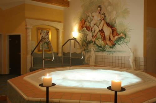 a large bath tub with two candles in it at Wellness- und Vitalhotel Böhmhof in Bodenmais