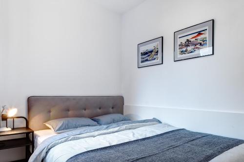 a bedroom with a bed with two pictures on the wall at Apartments Viola in Zagreb