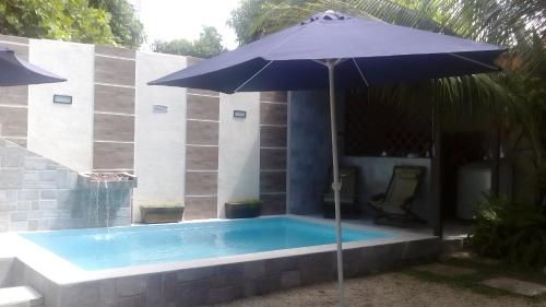un parasol bleu assis à côté d'une piscine dans l'établissement Aguasclaras Residencial, à Manaus
