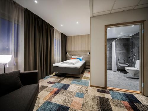 una camera d'albergo con letto e specchio di ArenaHotellet i Uppsala a Uppsala