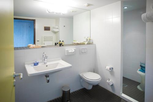 ein weißes Badezimmer mit Toilette und Waschbecken in der Unterkunft L'Ermitage Hôtel Cuisine-À-Manger in Saint-Cyr-au-Mont-dʼOr