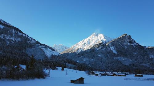 a snow covered mountain range with a village in the foreground at Alpenchalet Vils Tirol in Vils