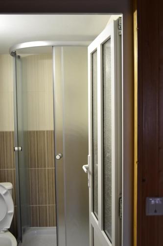 a bathroom with a shower with a toilet and a glass door at У Гуцула in Mukacheve