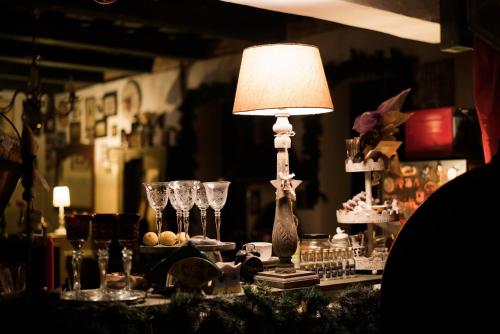 a table with a lamp and wine glasses on it at Vila Terrasse in Košice