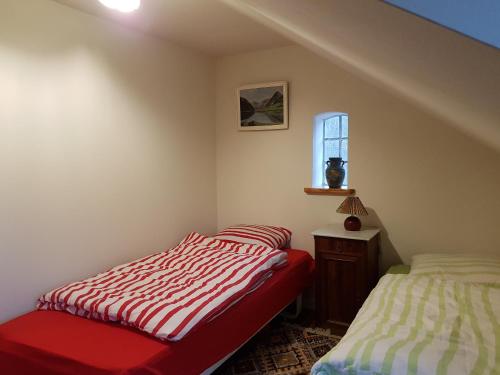 AugustenborgにあるHelved Skovmølle B&Bのベッドルーム1室(ベッド2台、赤いベンチ、窓付)