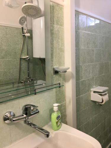 a bathroom with a sink and a shower with a mirror at Hotel Rade 1 in Vratsa