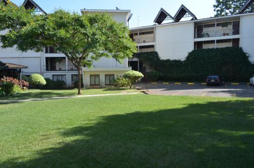 a large building with a tree in front of it at Jacaranda Hotel Nairobi in Nairobi