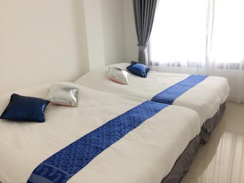 Una cama con mantas y almohadas azules y blancas. en @CHAIN Pool Villa en Hua Hin