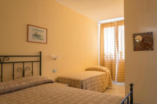 um quarto com 2 camas e uma janela em Le Terre Di Toscana em Casa Pallini