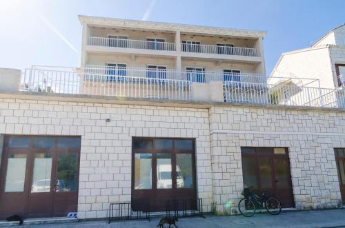 a building with a balcony on top of it at Apartments Angelo in Polače