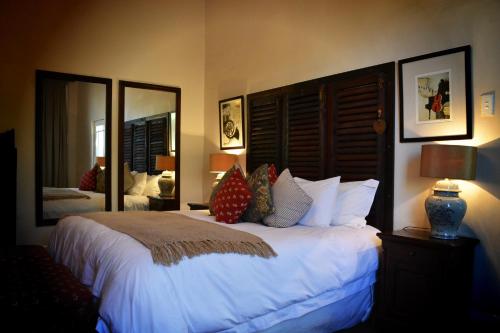sypialnia z dużym łóżkiem z białą pościelą i poduszkami w obiekcie Roche House w mieście Queenstown