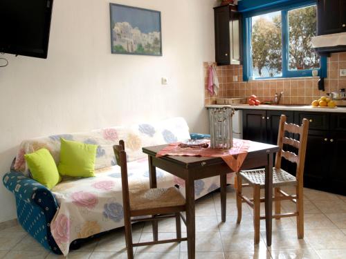 a living room with a couch and a table and a kitchen at Melenio Studios in Livadi Astypalaias