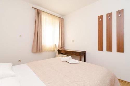 a bedroom with a bed with two towels on it at Apartments Angelo in Polače