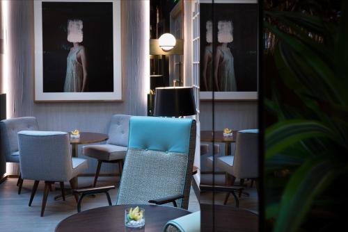 a dining room with chairs and tables and a painting at Maison Bréguet in Paris