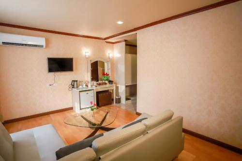 a living room with a couch and a glass table at Korat Hotel - SHA Plus in Nakhon Ratchasima