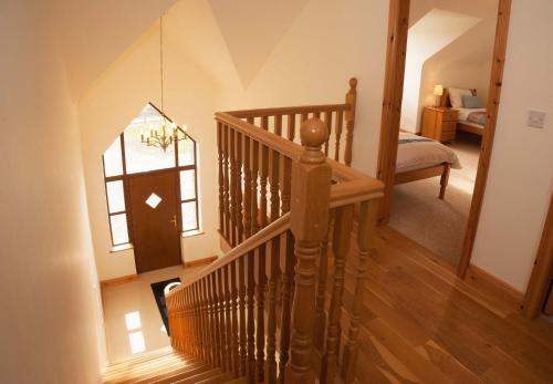 a staircase in a room with a bed and a window at Cottage 238 – Cleggan in Cleggan