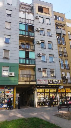 un edificio de apartamentos alto con tiendas enfrente en Marina Jacuzzi Apartment free parking, en Novi Sad
