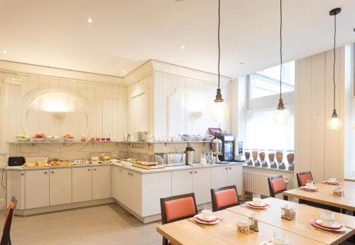 a kitchen and dining room with tables and chairs at Hotel Gravensteen in Ghent