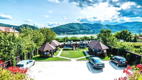 una vista aérea de una casa con coches aparcados en un aparcamiento en Pensiunea Camena, en Piatra Neamţ