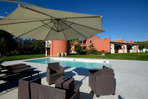 un grande ombrellone seduto accanto alla piscina di Contado San Lorenzo B&B and Wine a Castilenti