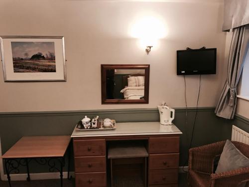 a hotel room with a desk and a mirror at The Red Lion Inn & Restaurant in Prestatyn