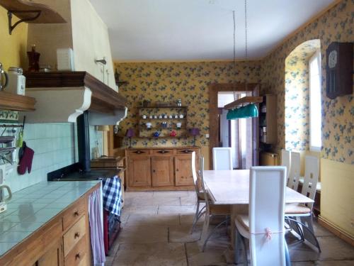 a kitchen with a table and a dining room at Château Bel-Air in Villers-Farlay