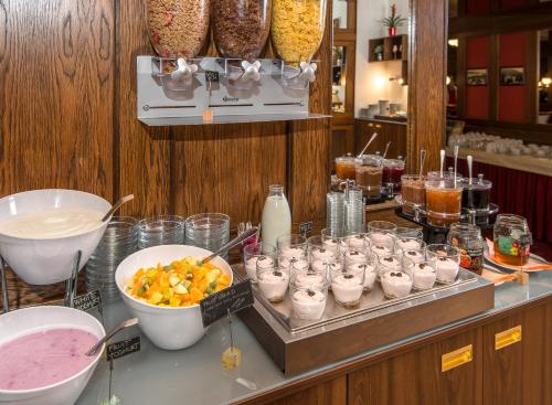 a counter with a bunch of drinks and a bunch of food at Hotel Continental in Mariánské Lázně
