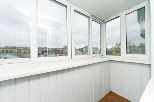 キーウにあるComfortable One Beds with nice view for Independent sqrの白い壁の客室で、窓が4つあります。