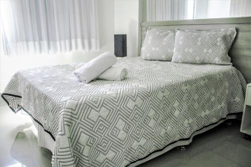 a white bed with a pillow on top of it at Apple Flat Natal in Natal