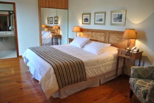 a bedroom with a large bed and a chair at Hotel Casablanca Koeler in Petrópolis