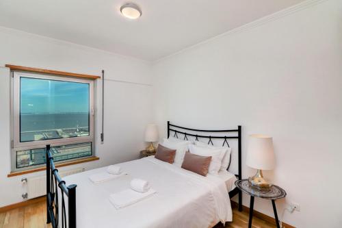 ein Schlafzimmer mit einem großen Bett und einem Fenster in der Unterkunft Baltico Residence in Lissabon