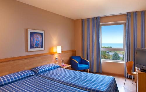 um quarto de hotel com uma cama e uma grande janela em Flag Hotel Valencia Florazar em Masalfasar