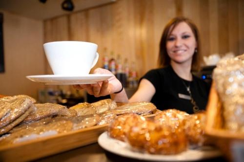 a woman is holding a plate of pastries at Jay Peak Resort in Jay