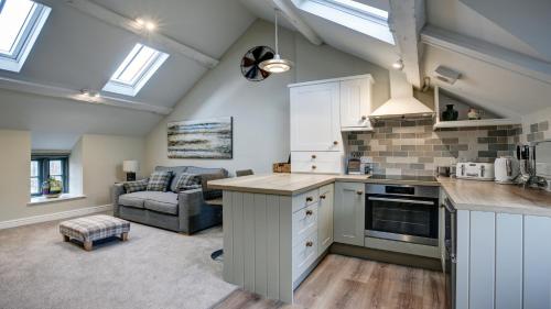 a kitchen and living room with a couch at The Snug - Llyn Peninsula in Pistyll