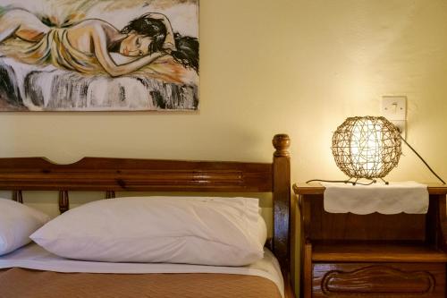 a bedroom with a bed with a painting on the wall at Seafront Paradise in Plataniás