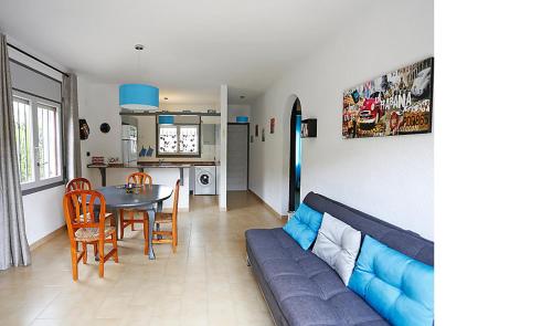 uma sala de estar com um sofá azul e uma mesa em Rentalmar Casa Horus em Miami Platja
