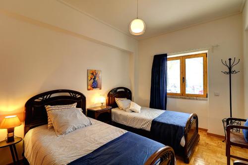 a bedroom with two beds and a window at Casa de Benfica in Lisbon