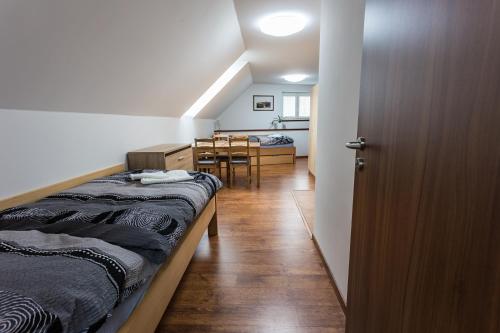 a bedroom with a bed and a dining room at Attic Rooms Tábor in Tábor