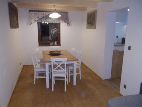 a dining room with a table and white chairs at U ponocného pod Ondřejníkem in Frýdlant nad Ostravicí