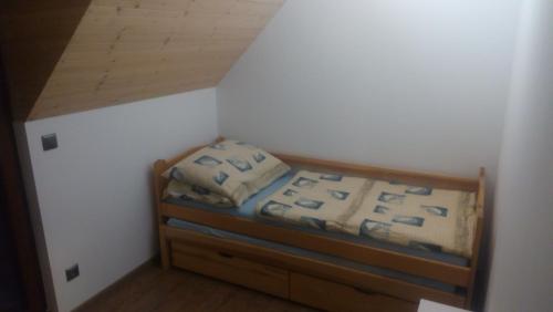 Dormitorio pequeño con cama con marco de madera en U ponocného pod Ondřejníkem, en Frýdlant nad Ostravicí