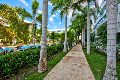 einen Fußweg durch Palmen neben einem Pool in der Unterkunft Estelar Playa Manzanillo - All inclusive in Cartagena de Indias