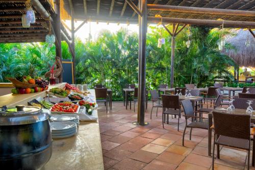 a restaurant with tables and chairs and food on a patio at Estelar Playa Manzanillo - All inclusive in Cartagena de Indias
