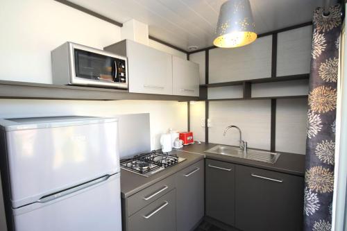 a kitchen with a white refrigerator and a stove at Lecci e Murta in Propriano