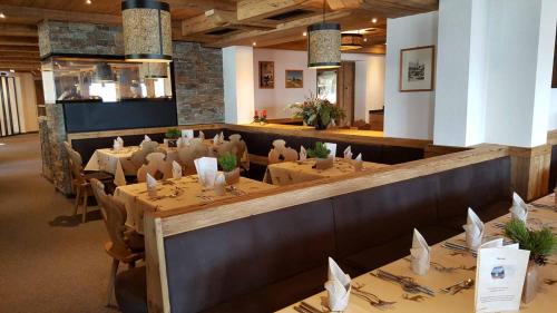 a restaurant with tables and chairs in a room at Berggasthof Schatzbergalm in Thierbach